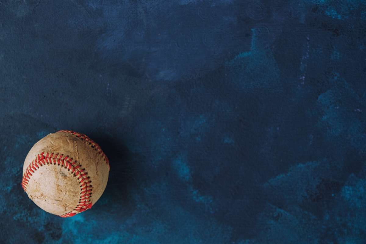 A baseball resting on a vibrant blue background