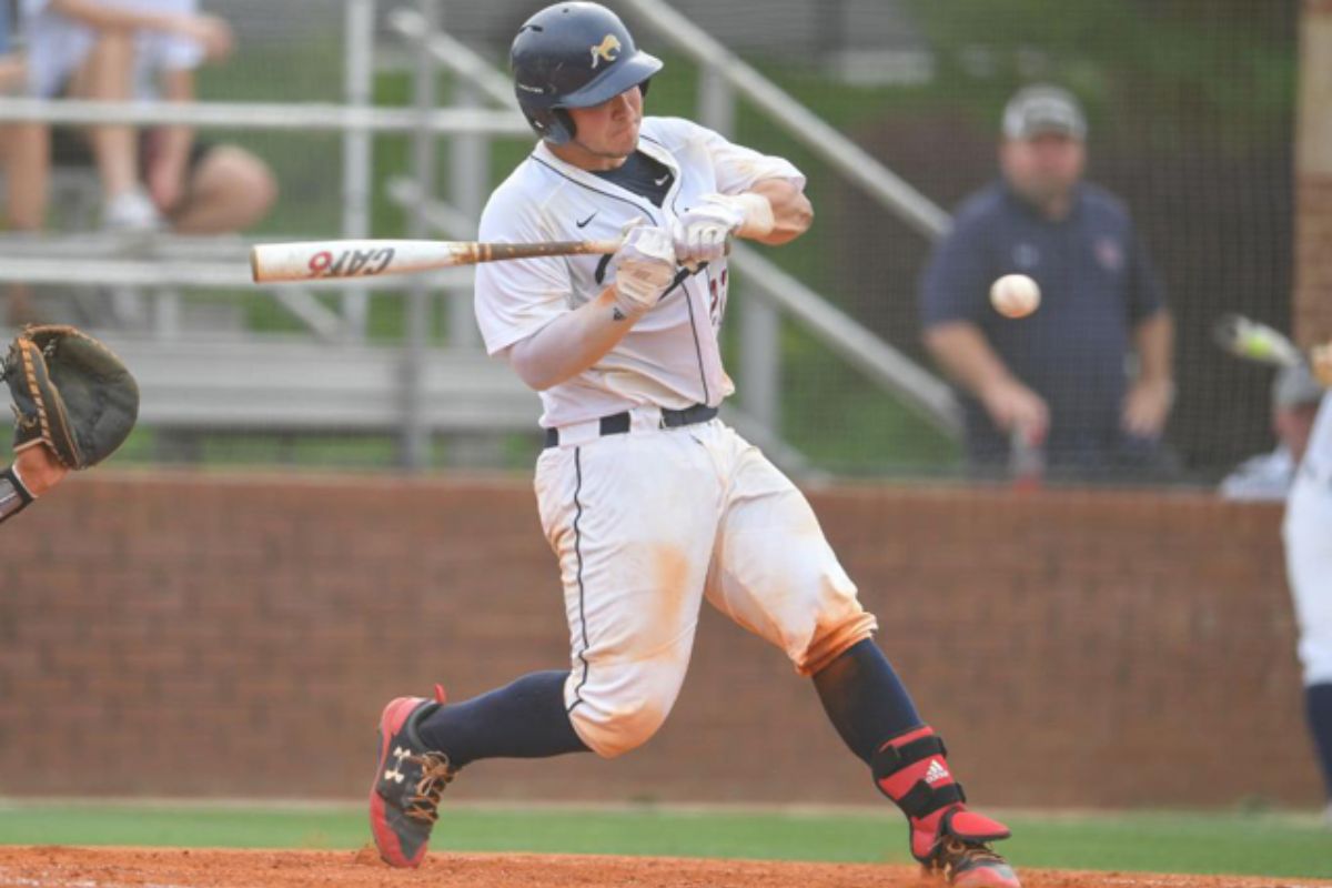 A baseball player in action, swinging at a pitch during a competitive game on the field.