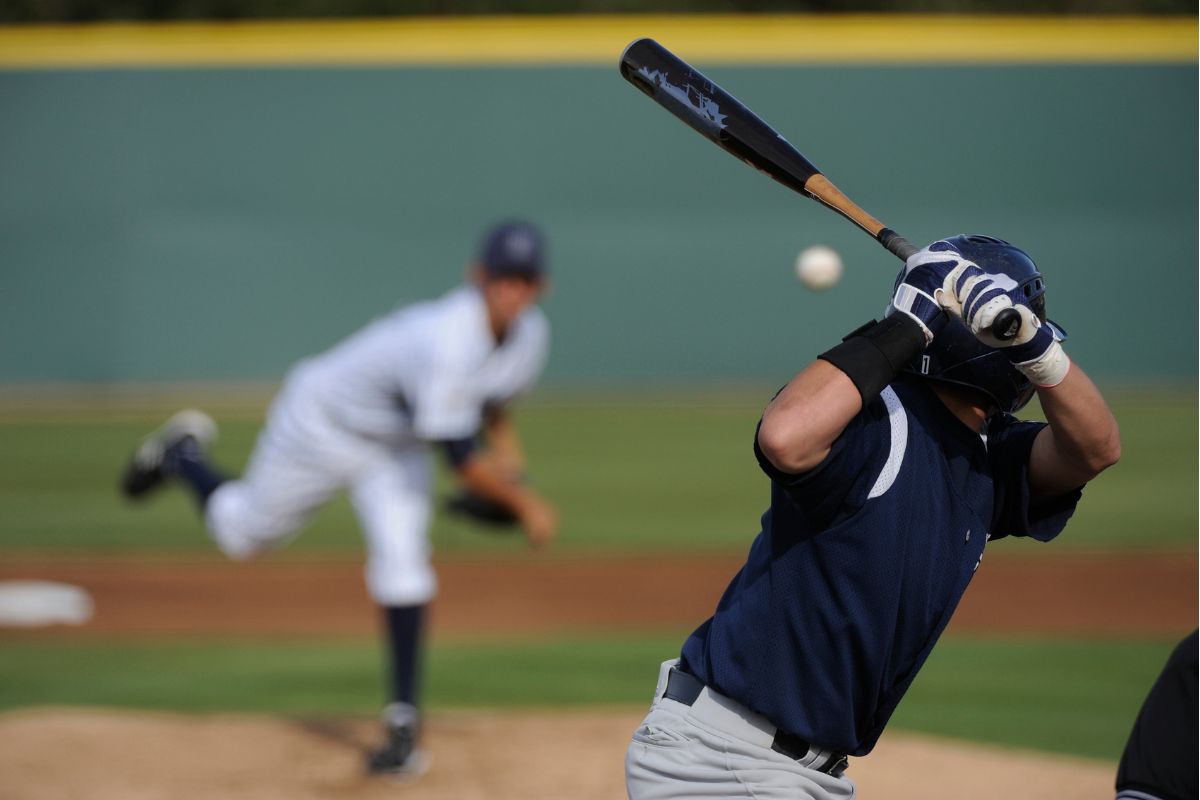 A baseball player in mid-swing, connecting with a ball